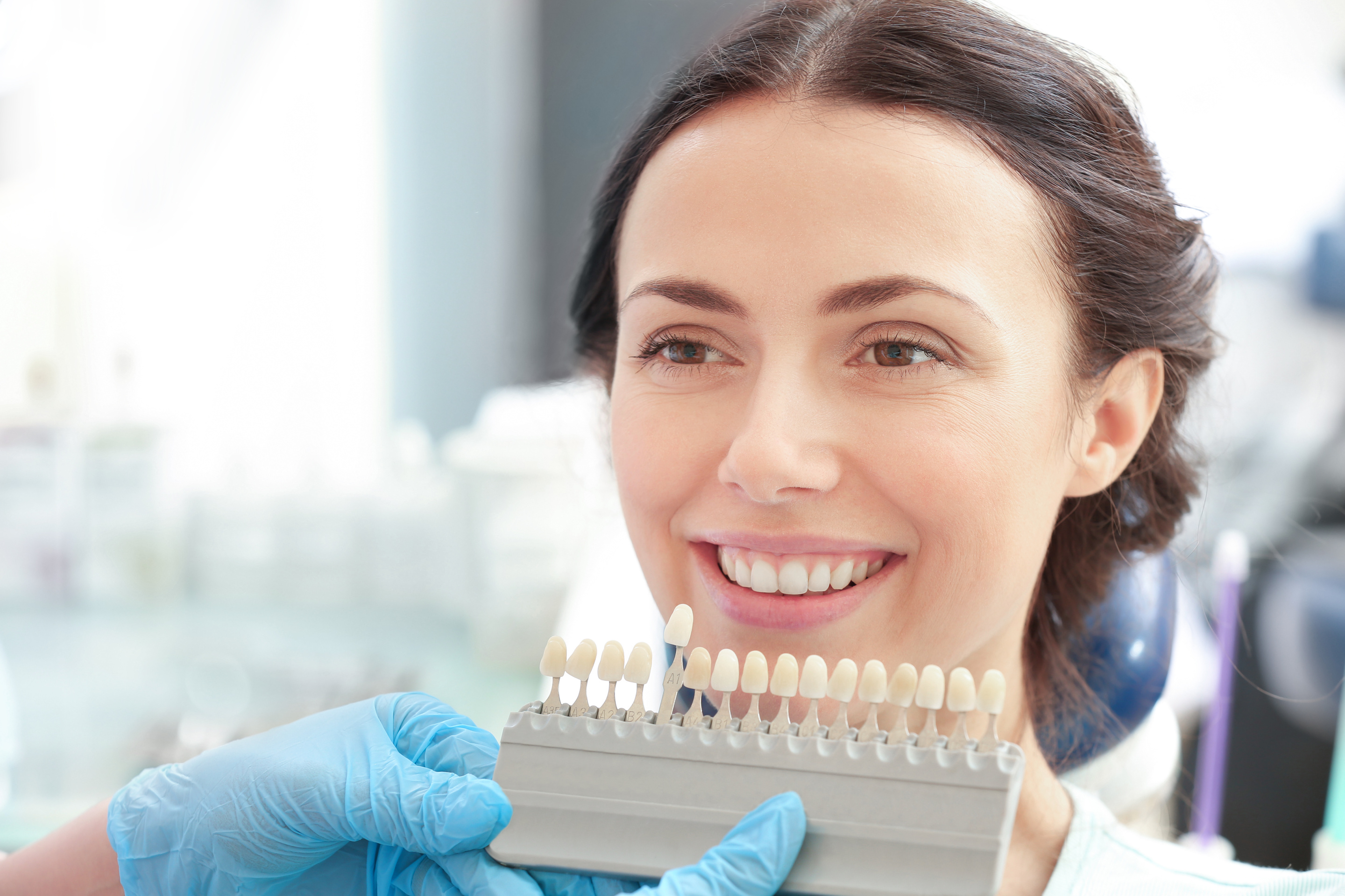 Dentist Checking and Selecting Young Woman's Teeth